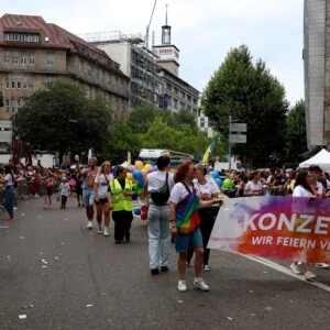 Breites Foto vom Demo Zug bei der CSD. Im Vordergrund laufen Konzept-e Mitarbeitende mit dem Banner.