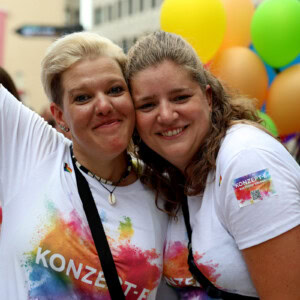 Eva und Ann-Kathrin lächeln beim CSD in die Kamera