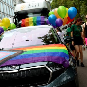 Auto von vorne mit Pride Flag und Luftballons