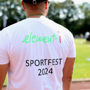 Mann von hinten mit weißem Shirt auf dem element-i Sportfest 2024 steht