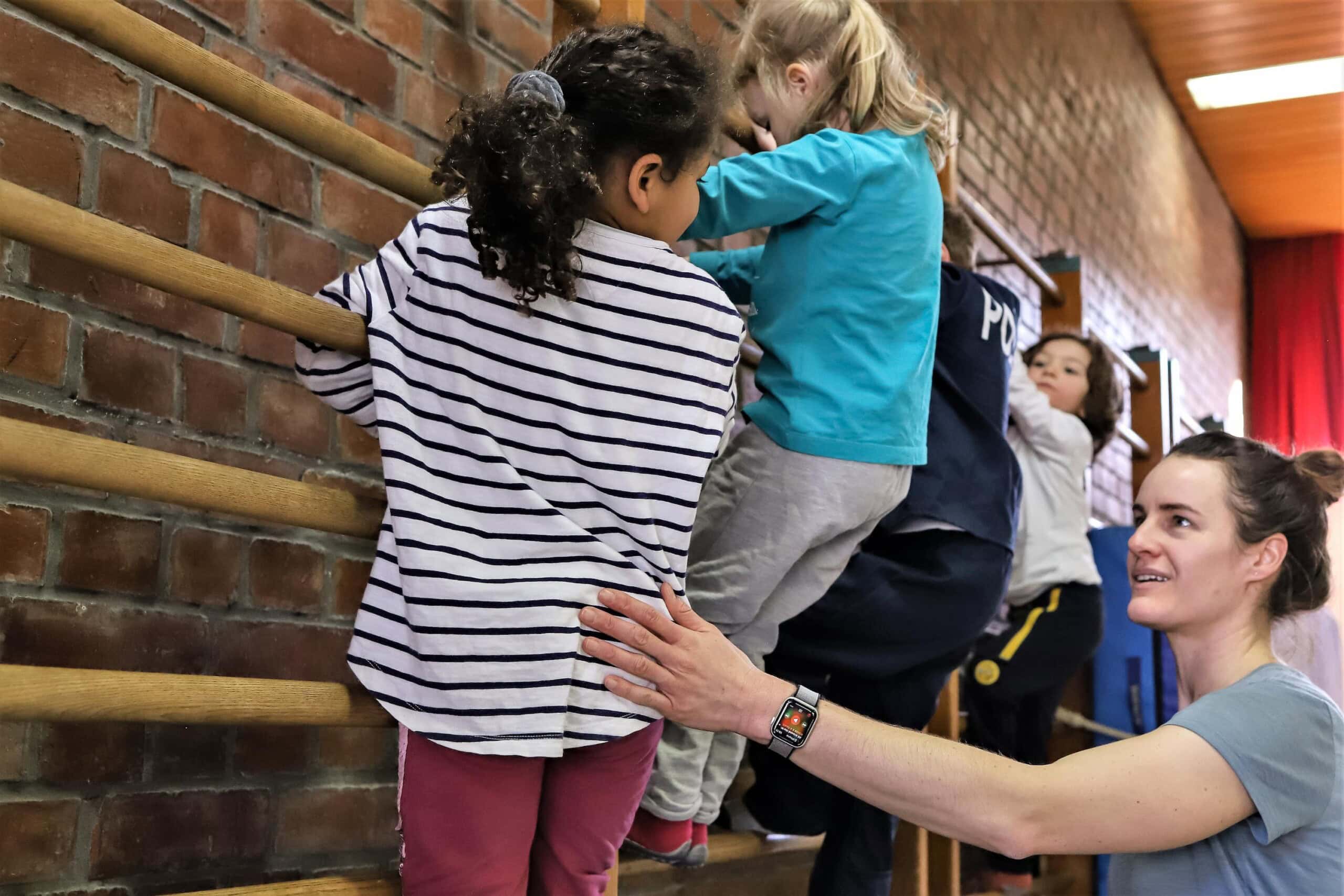 eine Erzieherin spricht mit Kindern beim Sport